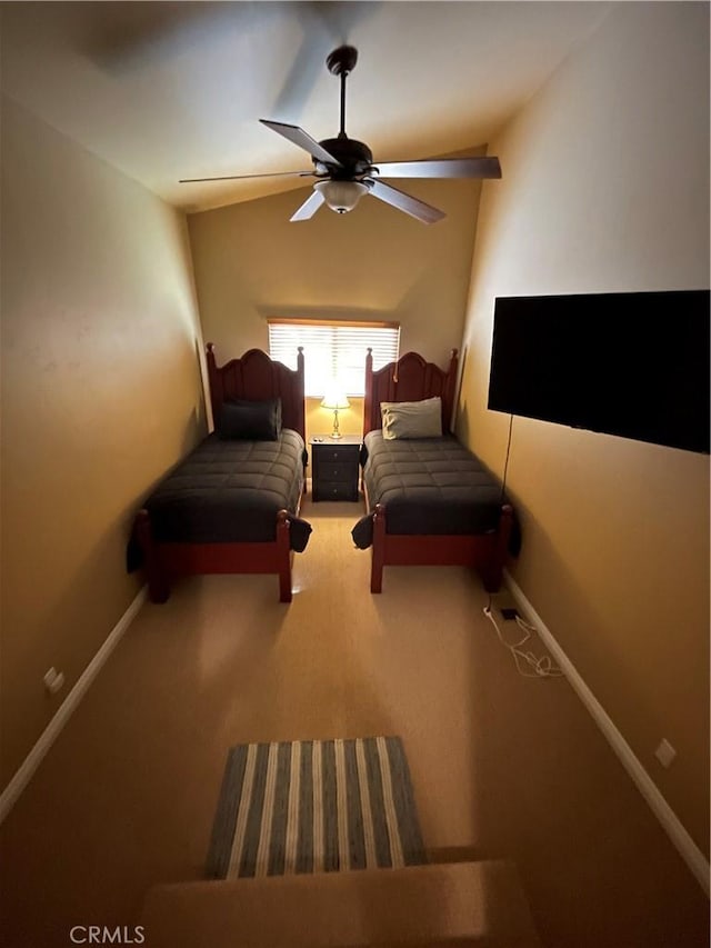 unfurnished bedroom with carpet flooring, ceiling fan, baseboards, and vaulted ceiling