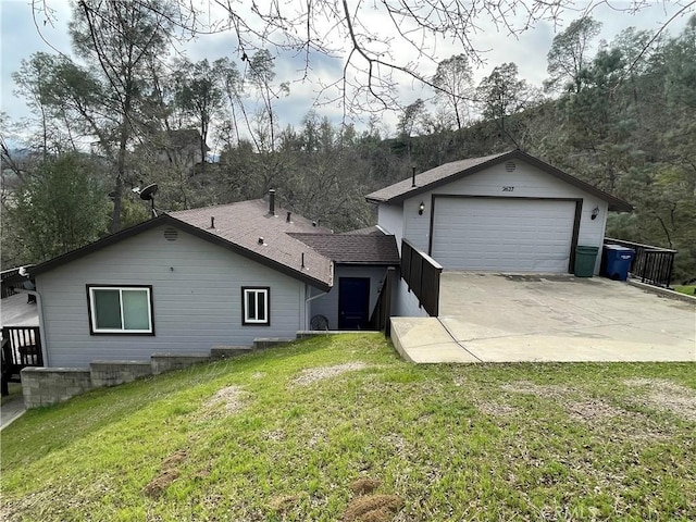 view of front of house with a detached garage, a front yard, and roof with shingles