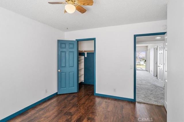 unfurnished bedroom featuring a closet, a textured ceiling, baseboards, and wood finished floors