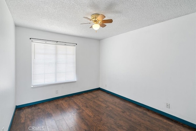 empty room featuring a textured ceiling, wood finished floors, a ceiling fan, and baseboards