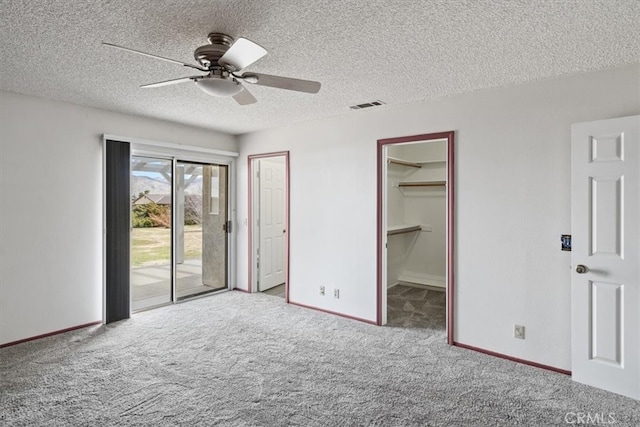 unfurnished bedroom featuring baseboards, visible vents, access to outside, a textured ceiling, and carpet floors