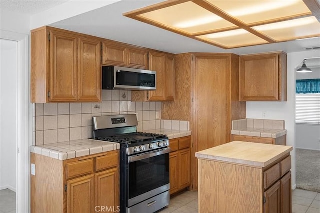 kitchen with visible vents, stainless steel appliances, backsplash, and light tile patterned flooring