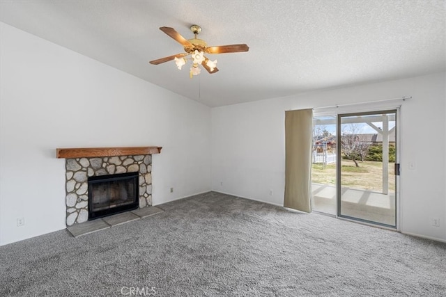 unfurnished living room featuring lofted ceiling, a textured ceiling, a fireplace, and carpet flooring