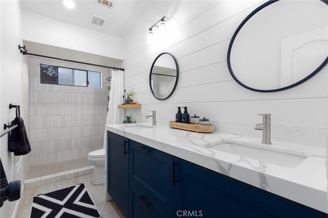 full bath with toilet, visible vents, a sink, and tiled shower