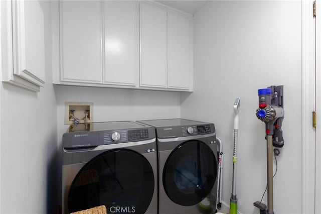 laundry room featuring washing machine and clothes dryer and cabinet space