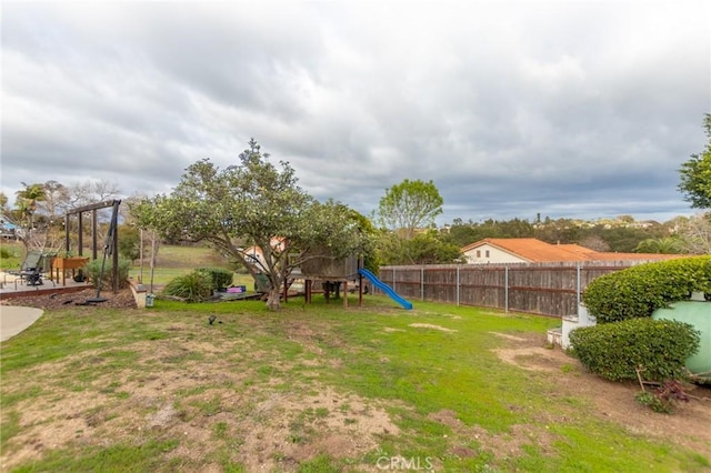 view of yard featuring a playground and fence