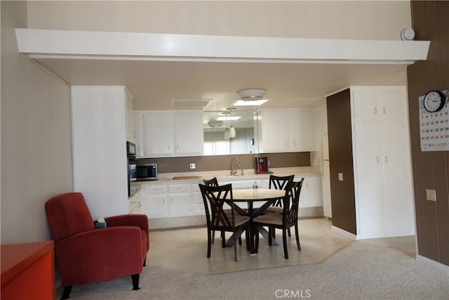 dining space featuring light carpet