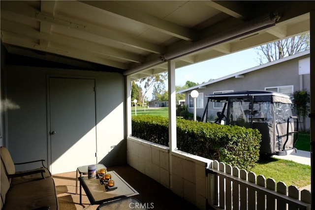 sunroom featuring beam ceiling