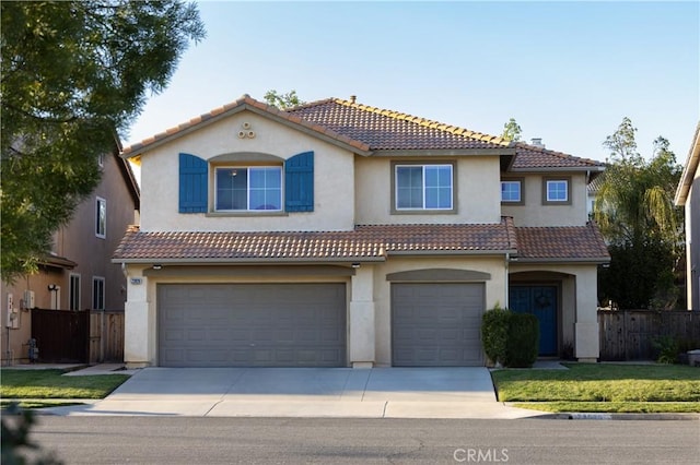 mediterranean / spanish-style house featuring a tile roof, fence, and stucco siding