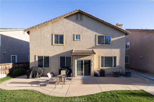 back of house featuring a patio, central AC, fence, and stucco siding