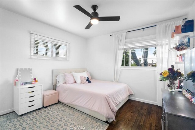 bedroom featuring multiple windows, wood finished floors, and baseboards