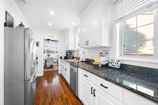 kitchen with a sink, dark wood-style floors, recessed lighting, stainless steel appliances, and white cabinets