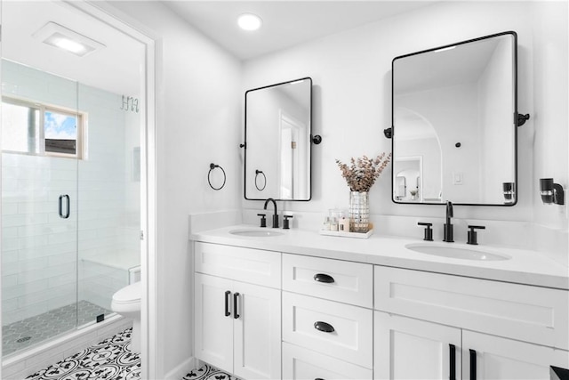 bathroom with double vanity, a stall shower, toilet, and a sink