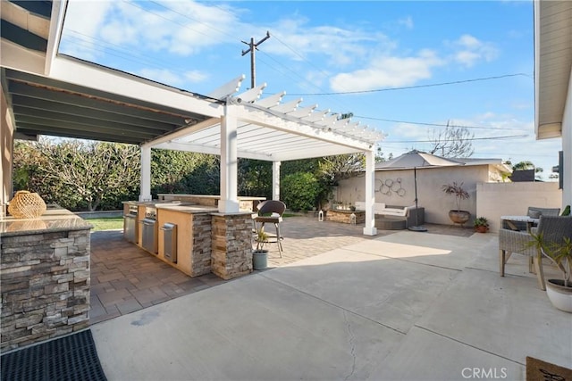 view of patio with area for grilling, fence, and a pergola