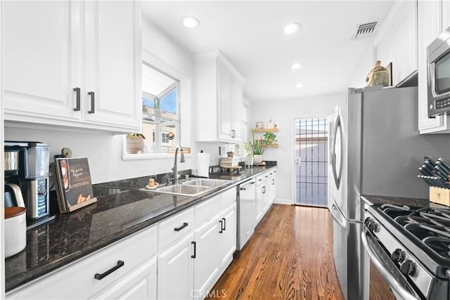 kitchen featuring a sink, stainless steel appliances, visible vents, and white cabinetry