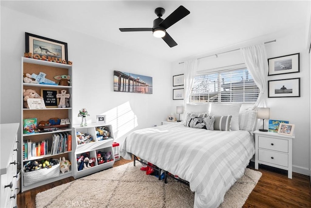 bedroom with ceiling fan, baseboards, and wood finished floors