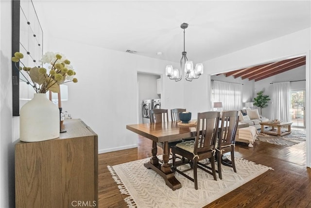 dining area featuring visible vents, vaulted ceiling with beams, washer and clothes dryer, a chandelier, and dark wood-style flooring