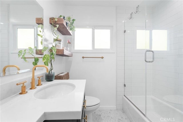 full bathroom with a wealth of natural light, toilet, vanity, and baseboards