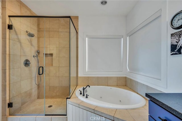 full bathroom featuring a shower stall, a tub with jets, and vanity