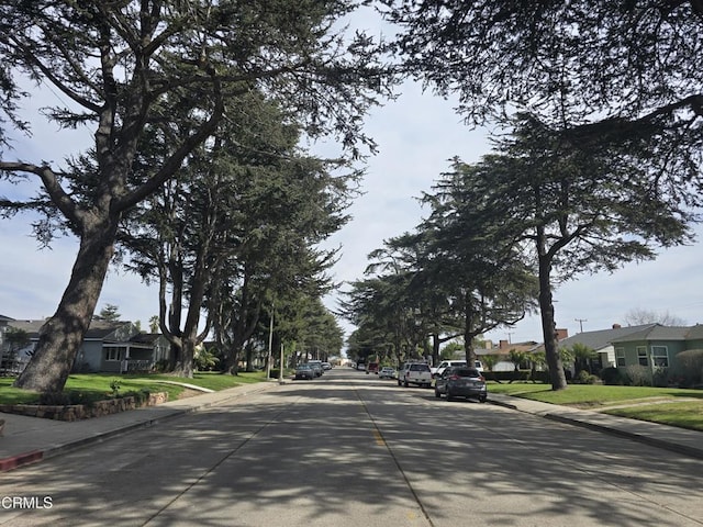 view of street with a residential view, curbs, and sidewalks