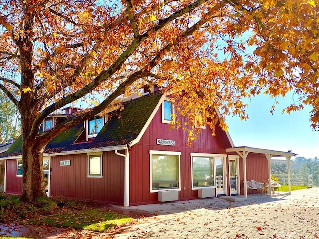 exterior space featuring a shingled roof and a patio area