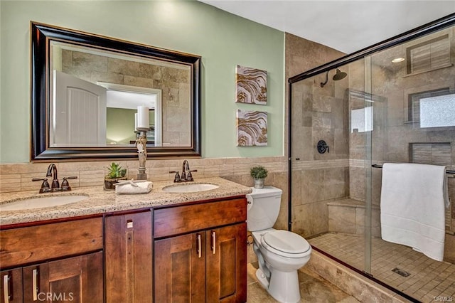 full bathroom with a sink, tile walls, and a shower stall