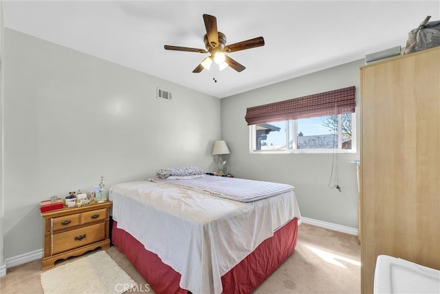 bedroom featuring light carpet, baseboards, visible vents, and a ceiling fan