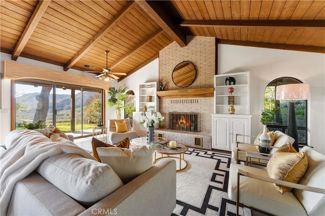 living room featuring vaulted ceiling with beams, wood ceiling, a brick fireplace, and a mountain view