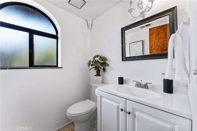 half bathroom with toilet, visible vents, and vanity