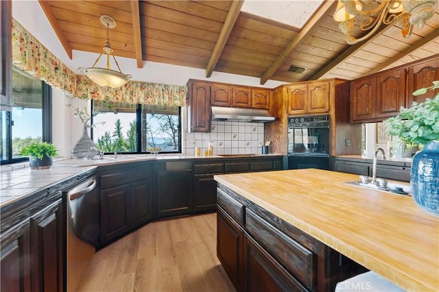 kitchen with vaulted ceiling with beams, under cabinet range hood, dobule oven black, a sink, and dishwasher