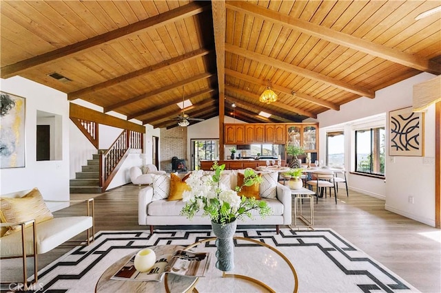 living room with stairs, light wood finished floors, lofted ceiling with beams, and wooden ceiling