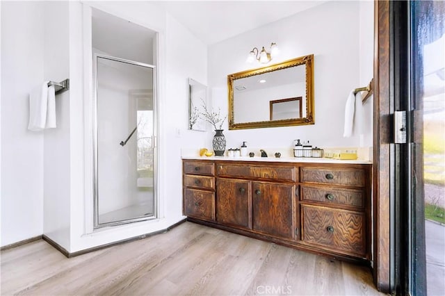 bathroom with a shower stall, vanity, and wood finished floors