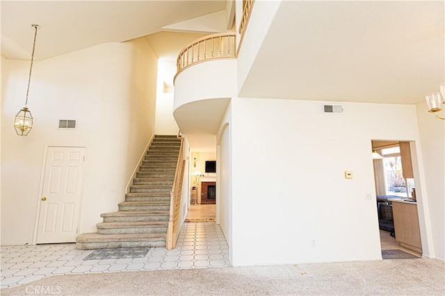 stairway featuring a notable chandelier, carpet, and visible vents