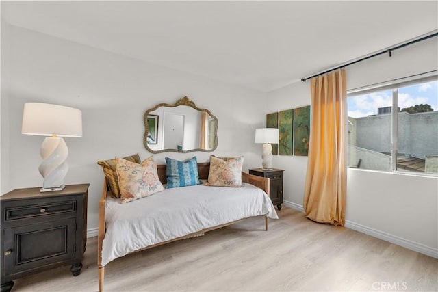 bedroom featuring baseboards and wood finished floors