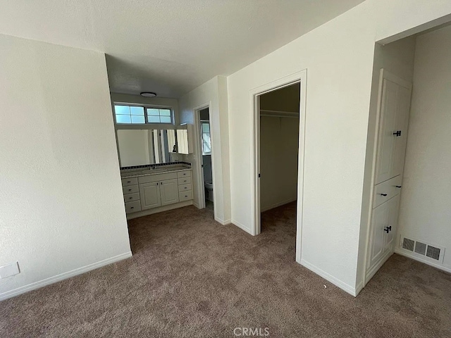 hall with baseboards, visible vents, and carpet flooring