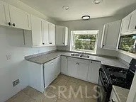 kitchen with black gas range and white cabinets