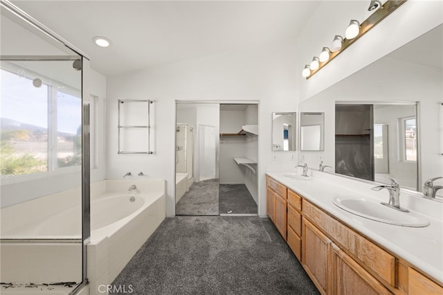 bathroom featuring vaulted ceiling, double vanity, a sink, and a garden tub