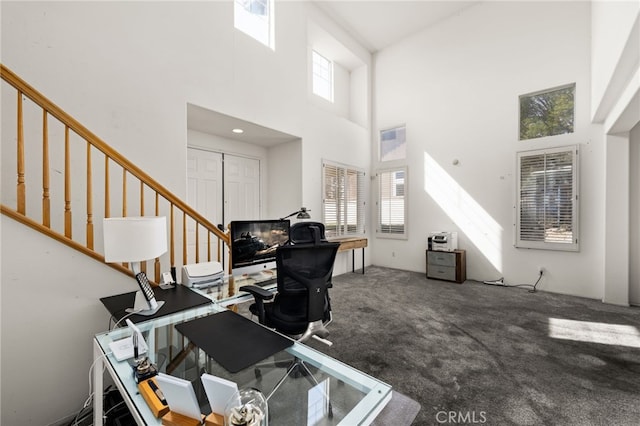 office area with a high ceiling and carpet