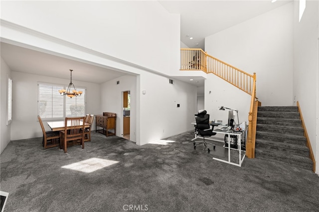 interior space featuring visible vents, a notable chandelier, a towering ceiling, and stairs