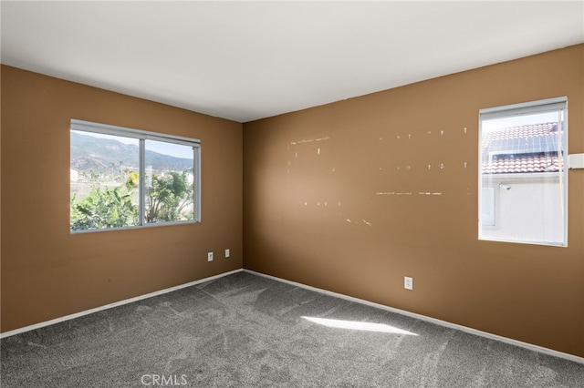 empty room featuring carpet floors and baseboards