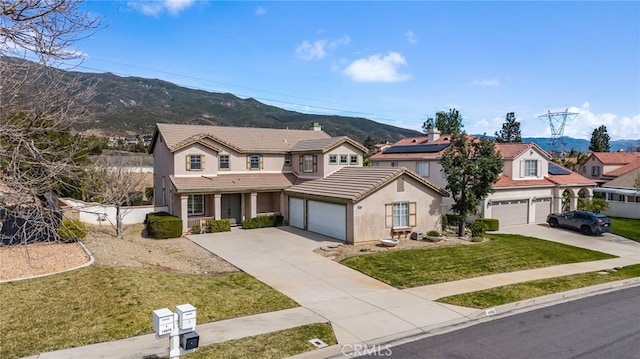 traditional-style home with a garage, driveway, a front lawn, and a mountain view