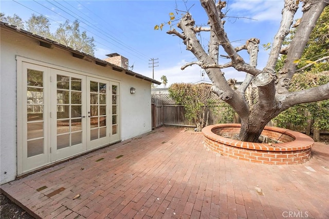 view of patio featuring french doors and fence