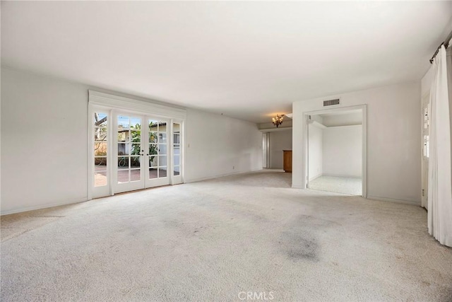 empty room with french doors, visible vents, and carpet flooring