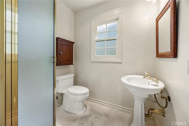 bathroom featuring toilet and baseboards