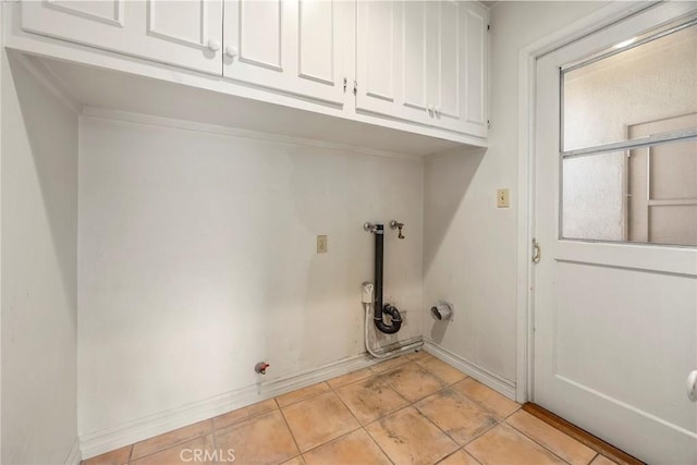 laundry room featuring cabinet space, light tile patterned floors, baseboards, and washer hookup