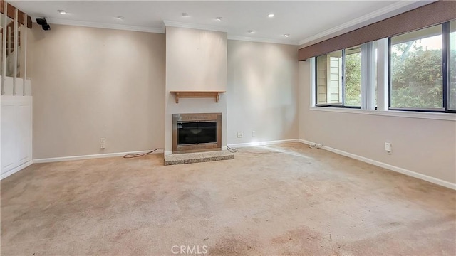 unfurnished living room with baseboards, a glass covered fireplace, ornamental molding, carpet flooring, and recessed lighting