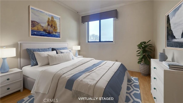 bedroom with crown molding, baseboards, and light wood-style floors