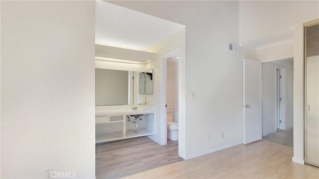 bathroom featuring toilet, baseboards, visible vents, and wood finished floors