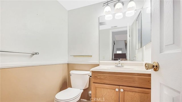 bathroom with visible vents, vanity, and toilet