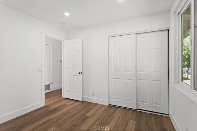 unfurnished bedroom featuring recessed lighting, wood finished floors, visible vents, baseboards, and a closet